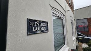 布莱顿霍夫The Windsor Lodge的建筑一侧的标牌,上面写着假发画