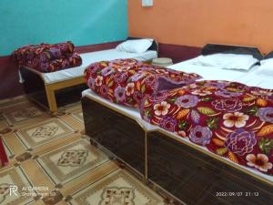 KedārnāthKedarnath Tent Prithvi yatra Hotel的铺有瓷砖地板的客房内设有两张单人床。