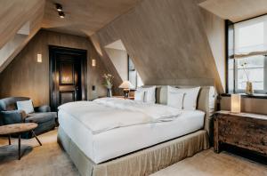 安德纳赫Hotel PURS的卧室配有一张白色大床和一把椅子