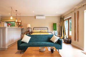 埃文河畔布拉德福Granby Estate The Old Pool House的客厅配有绿色沙发和床。