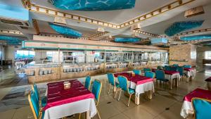 凯麦尔Daima Biz Hotel - Dolusu Aquapark Access的一间带桌椅和柜台的餐厅