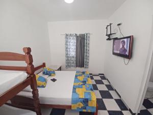 博拉塞亚Pousada Luar de Boracéia的一间卧室配有一张腿床和一台电视。