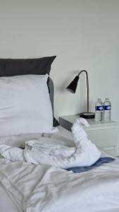 圣路易Traumhaftes Studio in Top Lage!的床上的白色毯子,带灯和水瓶