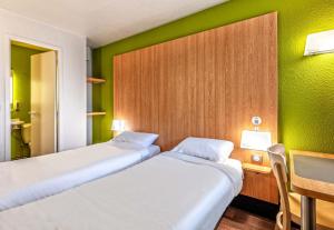 布雷斯特B&B HOTEL Brest Kergaradec Aéroport Gouesnou的绿墙客房内的两张床