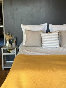 克拉伦斯Clarens Tranquil Mountain Villa的一张带黄色毯子和枕头的床