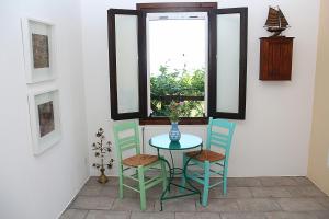 卡尔利拉基塔索斯拉达诺斯公寓的一张桌子,上面有两把椅子和一个花瓶