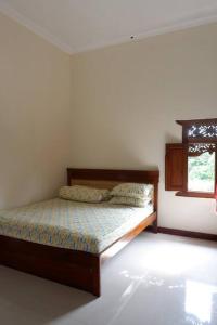 梭罗Omah Pinaringan的一间带床的卧室,位于带窗户的房间内