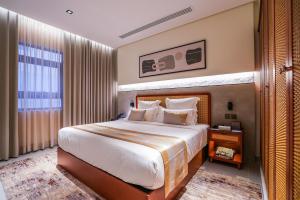 利雅德Vivian Park El Raeid Hotel的一间卧室设有一张大床和一个大窗户