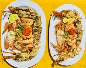 尼甘布The Kingslayer Resort的桌上有两盘带虾和面食的食物