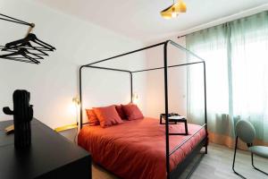 阿格德Appartement T3 la perle verte的一间卧室配有一张红色的床和玻璃天篷
