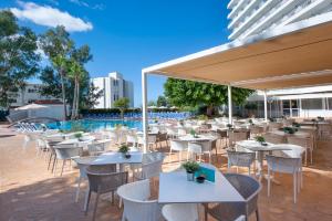 马盖鲁夫圣米歇尔大西洋公园酒店的一间带桌椅的餐厅和一个游泳池