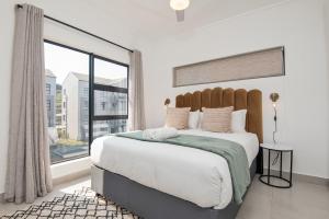 巴利托Ballito Village Luxury Apartments的一间卧室设有一张大床和大窗户