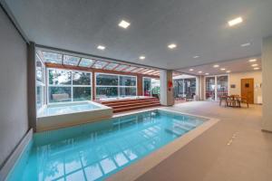 格拉玛多Hotel Laghetto Stilo Borges Gramado RS的一座大游泳池,位于一座房子内,设有浴缸
