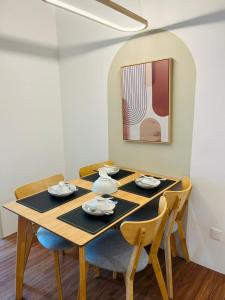 梳邦再也Harmony and Deluxe Studio Subang Jaya的一张餐桌,配有四把椅子和一幅画