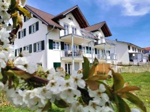 瓦瑟堡Landhaus Vogel - helle und lichtdurchflutete Maisonette-Ferienwohnung的白色房子前面有白色的花