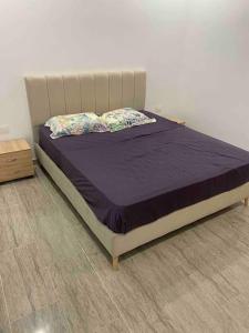 哈马马特Dar Selima by Amin BenSassi的卧室内的一张床铺,配有紫色床罩