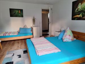 阿巴斯塔特Schöni´s Zimmer的一间设有两张蓝色床单的床的房间和一间设有