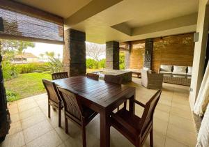 Centre de FlacqPrivate Beach 5-star Villa, Golf & Luxe的客厅配有一张木桌和椅子