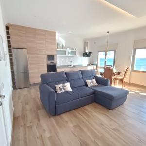 阿里纳加Sea View on Arinaga Beach的一间带蓝色沙发的客厅和一间厨房