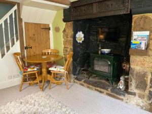 HatherleighLemon Cottage的一间带桌子和炉灶的客厅