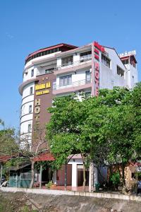 Hào GiaKhách sạn Hoàng Hà River Town的一座高大的白色建筑,上面有标志