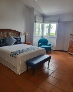 里奥格兰德Beautiful Villa at The Rio Mar Beach Resort的一间卧室配有一张床和一张蓝色椅子