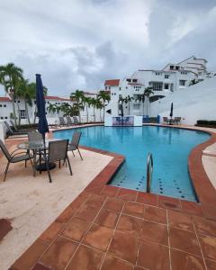 里奥格兰德Beautiful Villa at The Rio Mar Beach Resort的一座带桌椅的游泳池以及建筑
