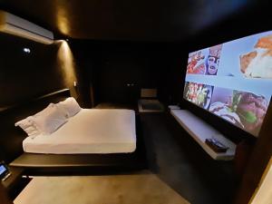 南卡希亚斯LUV Gardens Motel - Adults Only的客房设有一张床和一台平面电视。