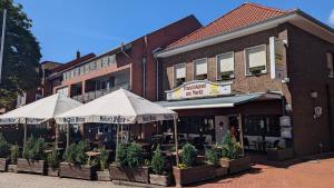 LöningenFranziskaner am Markt的前面有桌子和伞的建筑