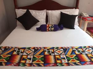 MeruThe Nido Hotel的床上配有色彩缤纷的被子和枕头
