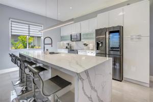 迈阿密Luxury, Art, design, patio grill, near Gables,Grove,Brickell的厨房配有大型大理石台面和冰箱。