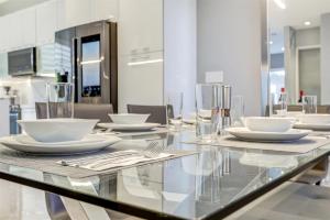 迈阿密Luxury, Art, design, patio grill, near Gables,Grove,Brickell的玻璃桌,上面有白色的板子和餐具