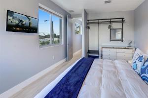 迈阿密Luxury, Art, design, patio grill, near Gables,Grove,Brickell的一间卧室设有一张大床和一台墙上的电视。