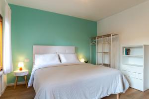 特雷维索Giustiniani Apartments的卧室配有白色的床和蓝色的墙壁