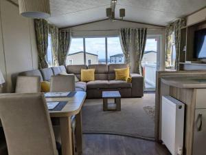 MainsriddleBeautiful Pet Friendly Southerness Caravan With Sea View & Decking Area的客厅配有沙发和桌子