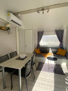 鲁西隆地区卡内Mobil-home 5 personnes dans camping Mar Estang 4 étoiles avec accès à la plage的一间带桌椅和沙发的用餐室