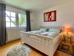 林道Ferienhaus Köchlin的卧室配有白色的床和窗户。
