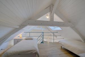 圣纳泽尔Le Harmony - Appart'Escale的阁楼卧室设有两张床和楼梯。