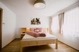 SchmirnNedererhof - Zimmer Alpenrose mit Gemeinschaftsküche的一间卧室配有带枕头的床