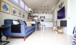 卡沃罗霍Casa Arrecife 28的一间带蓝色沙发的客厅和一间厨房