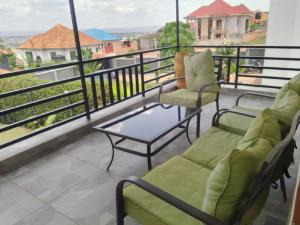 基加利Kagarama Residential House:的阳台配有两把椅子和茶几