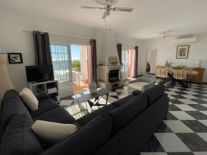 圣巴巴拉-迪内希Cabana do Monte的客厅配有黑色沙发和 ⁇ 格地板