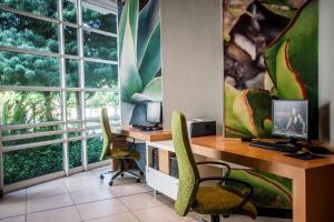 约翰内斯堡桑顿城花园科尔特酒店的办公室设有两把椅子和一张桌子及电脑