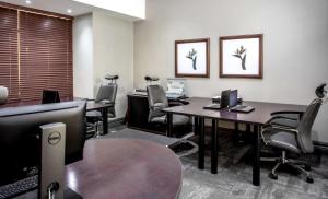 卢萨卡Southern Sun Ridgeway Lusaka的办公室配有2张桌子、椅子和桌子