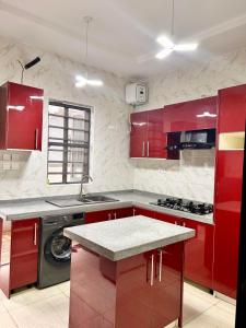 拉各斯Homely Shortlet Apartment LBS, AJAH的红色的厨房,配有红色橱柜和水槽