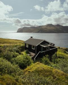 LeynarCottage with stunning view of the sea and islands.的湖畔的一座黑色小房子