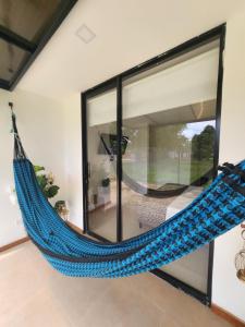 莱蒂西亚Amazonia Deluxe Lake Condo的挂在房间的蓝色吊床