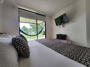 莱蒂西亚Amazonia Deluxe Lake Condo的一间卧室设有一张大床和一个大窗户