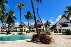 平圭Ocean Front Villa with pool, Zanzibar的一个带游泳池和棕榈树的度假村