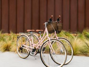 棕榈泉ARRIVE Palm Springs - Adults Only的一辆粉红色的自行车,两篮子停在人行道上